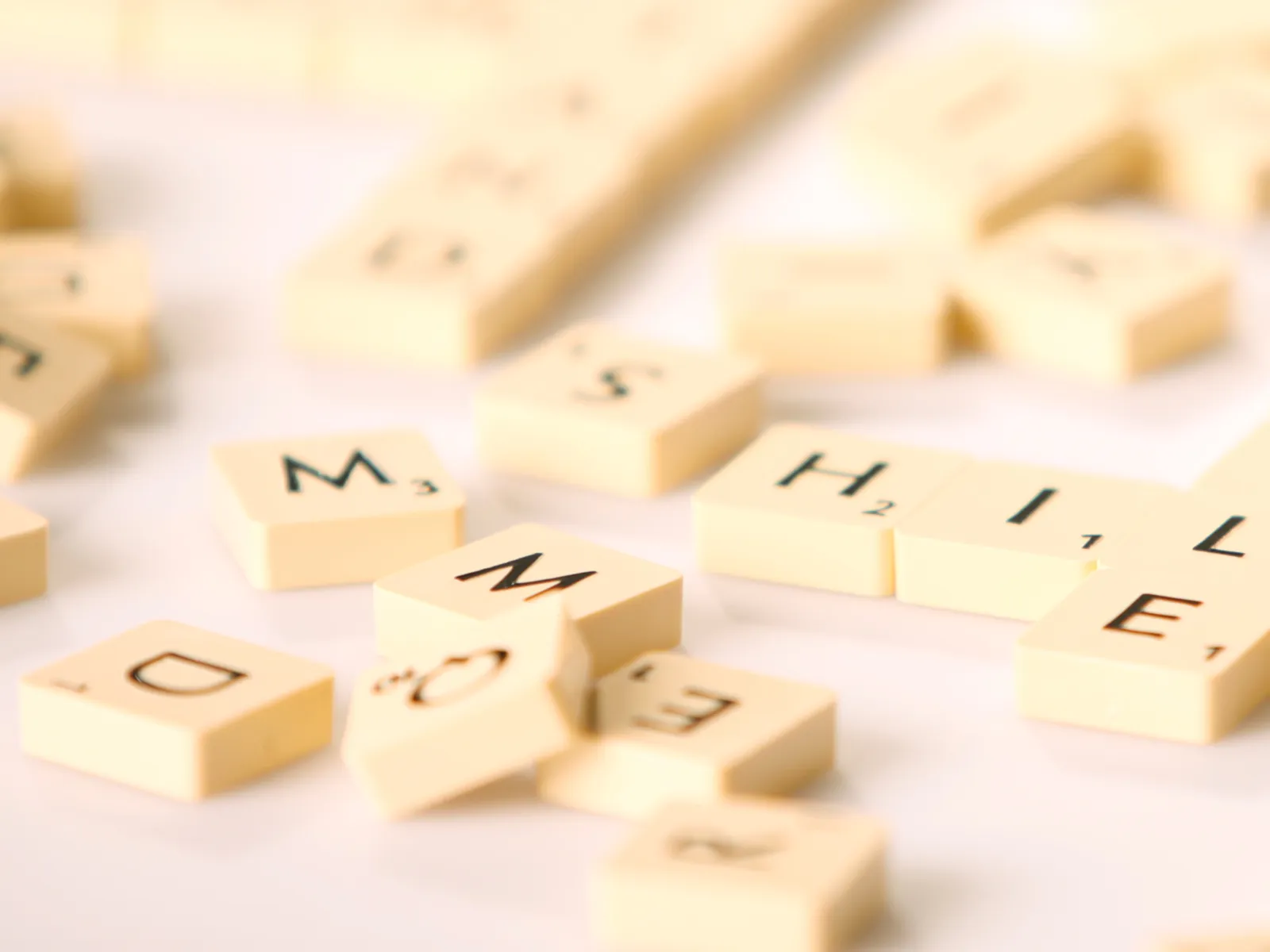 Spielsteine tragen einzelne Buchstaben und liegen durcheinander.