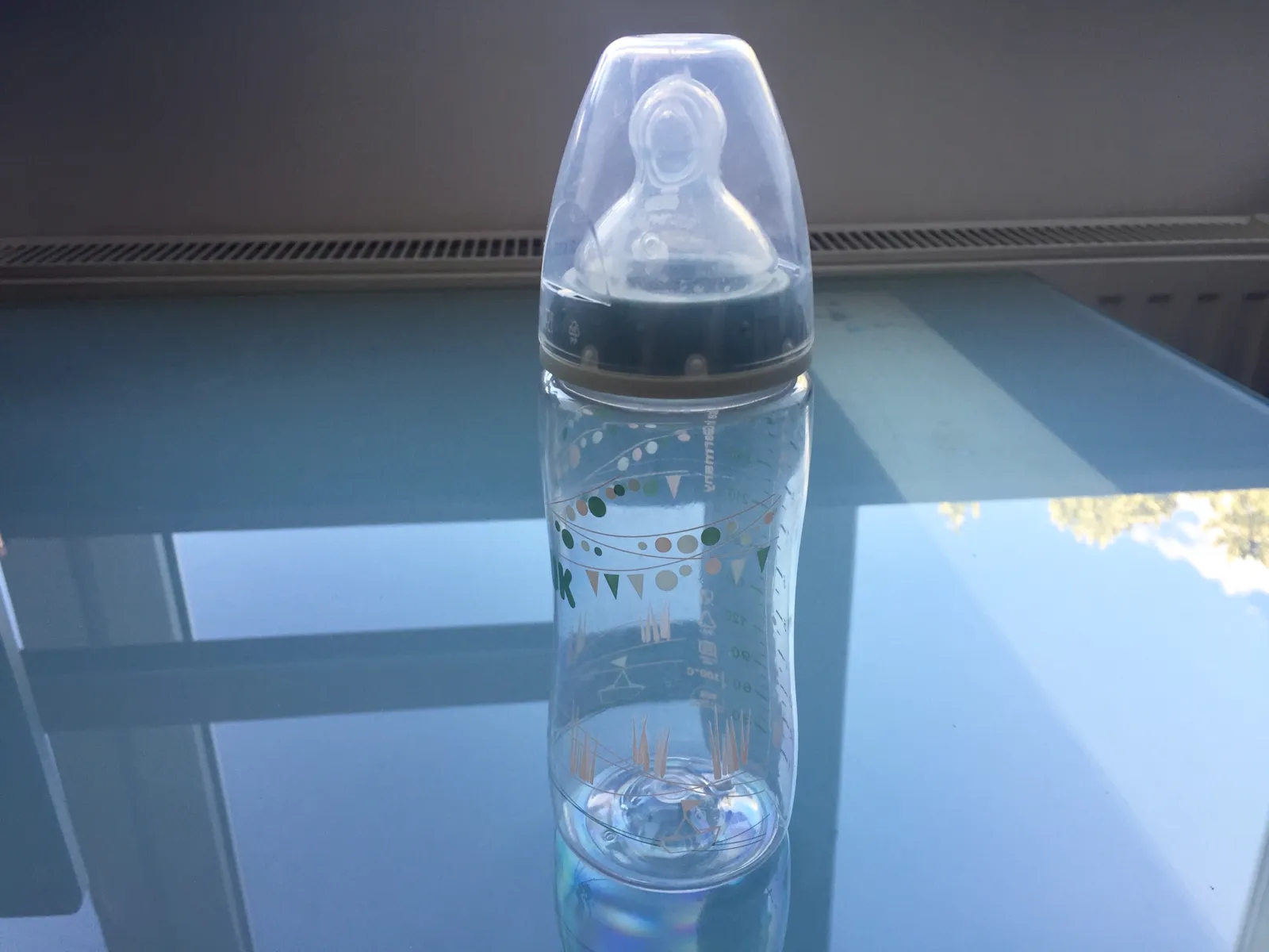 Nuckelflasche auf einem Glastisch