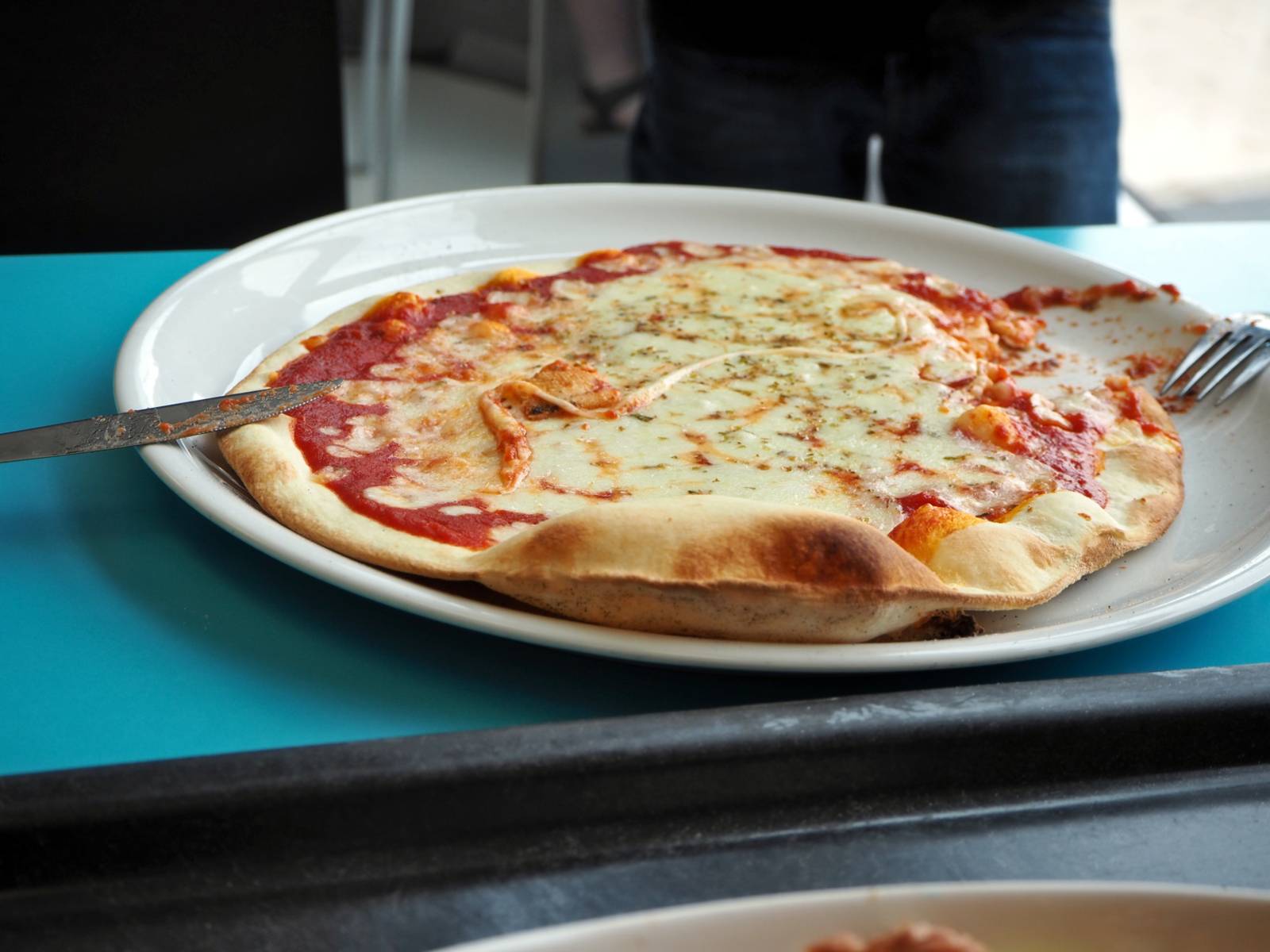 Eine verzehrbereite Pizza liegt auf einem Teller.