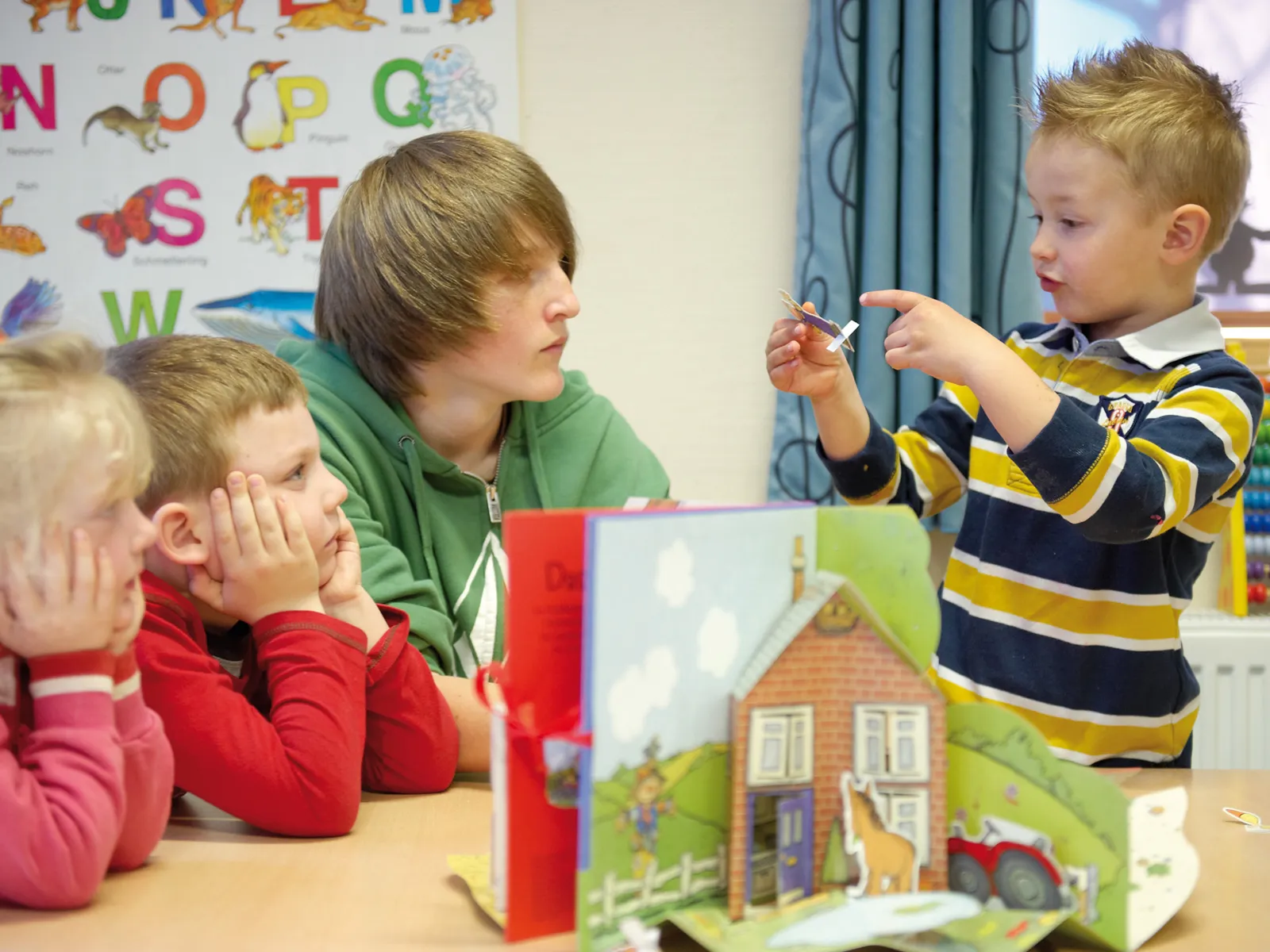 Junger Mann betreut drei kleine Kinder