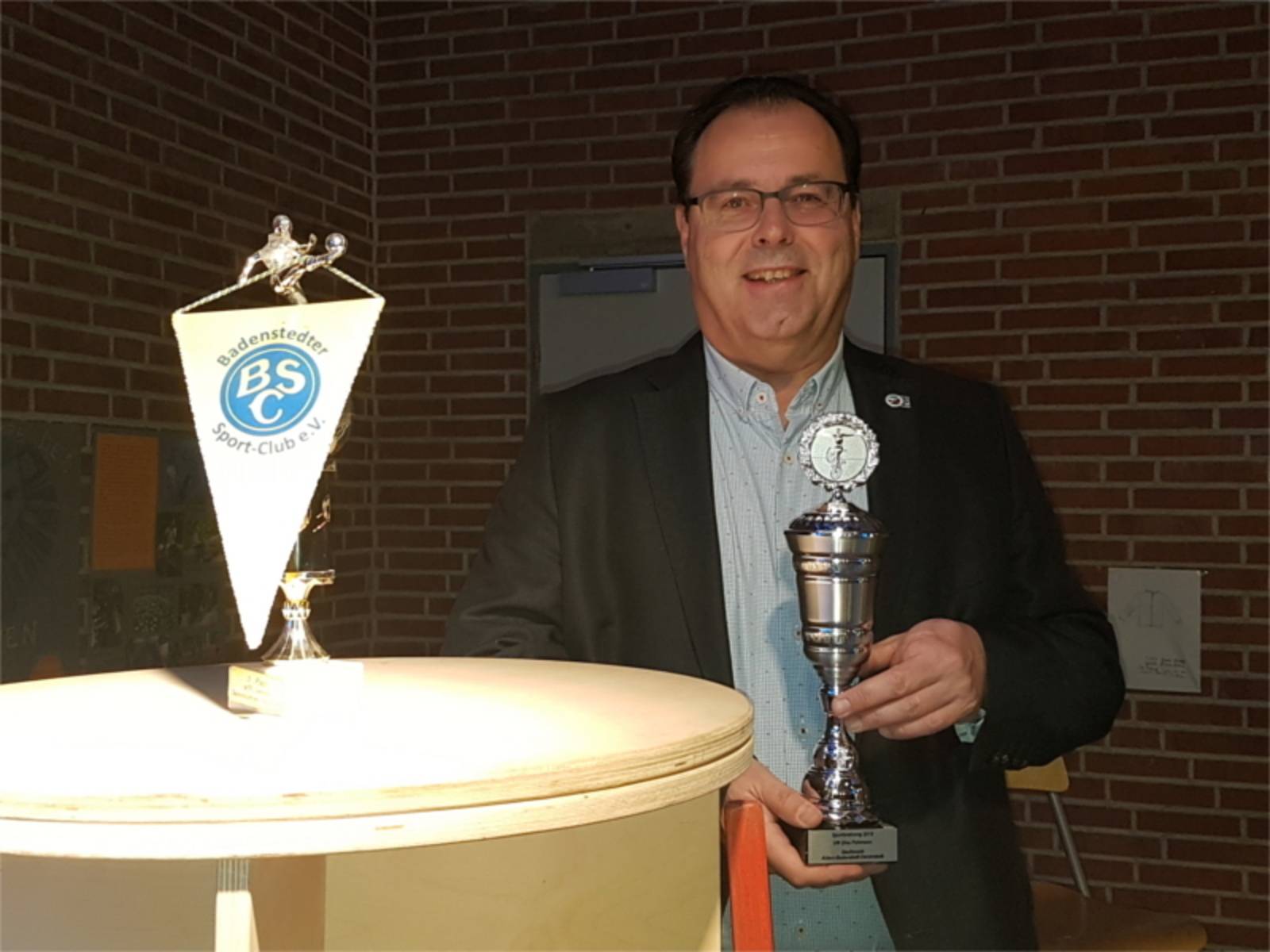 Bezirksbürgermeister Rainer Göbel übergibt Pokale an die erfolgreichen SportlerInnen.