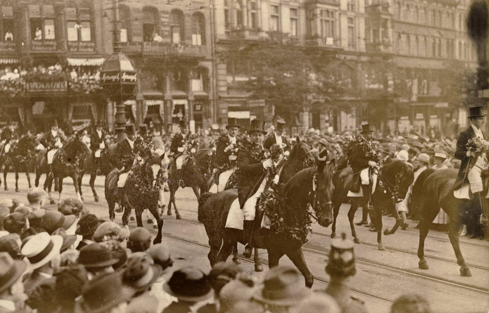 Schützenausmarsch Hannover, Foto, 1925:  Das Bild zeigt Reiter auf geschmückten Pferden, vermutlich am Kröpcke. Die Straße ist gesäumt von einer dichtgedrängten Menschenmenge.