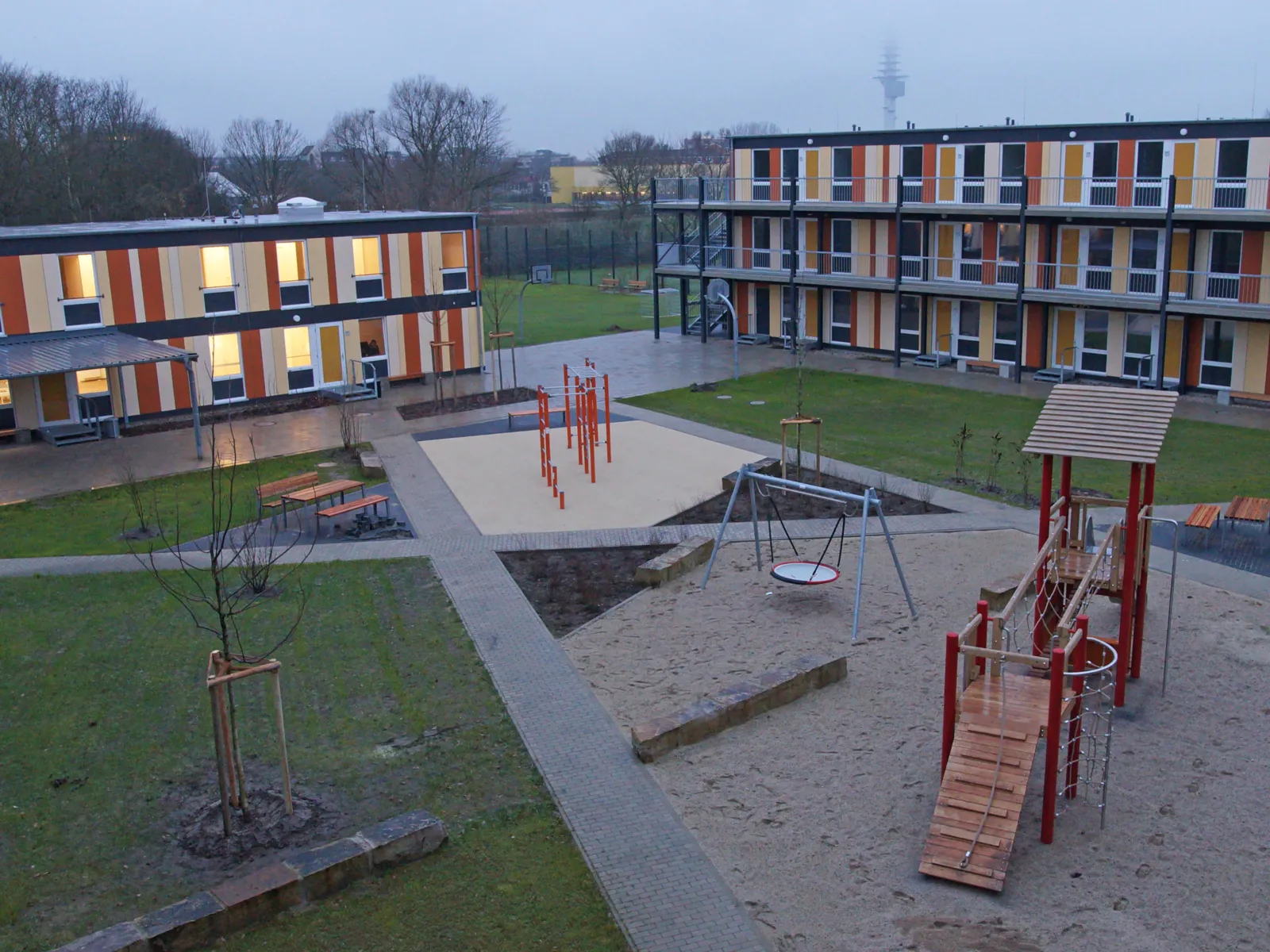 Ein Hof, gesäumt von Gebäuden. Darauf ein Spielplatz. 