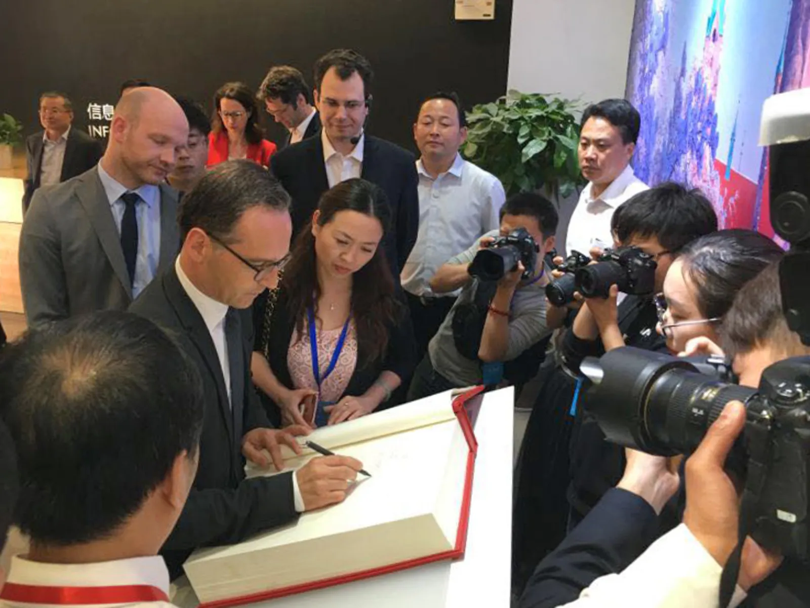Heiko Maas trägt sich ins Gästebuch im Hannover-Haus ein