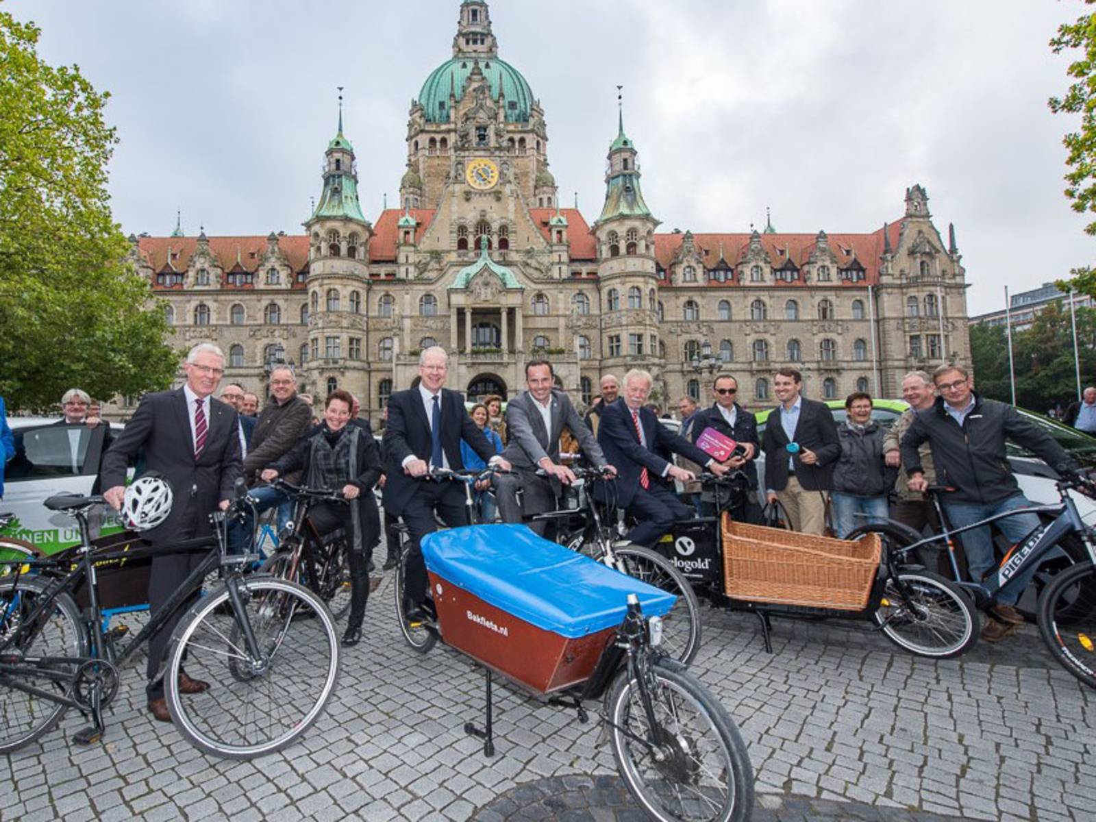 Menschen mit Fahrrädern und Elektroautos. 