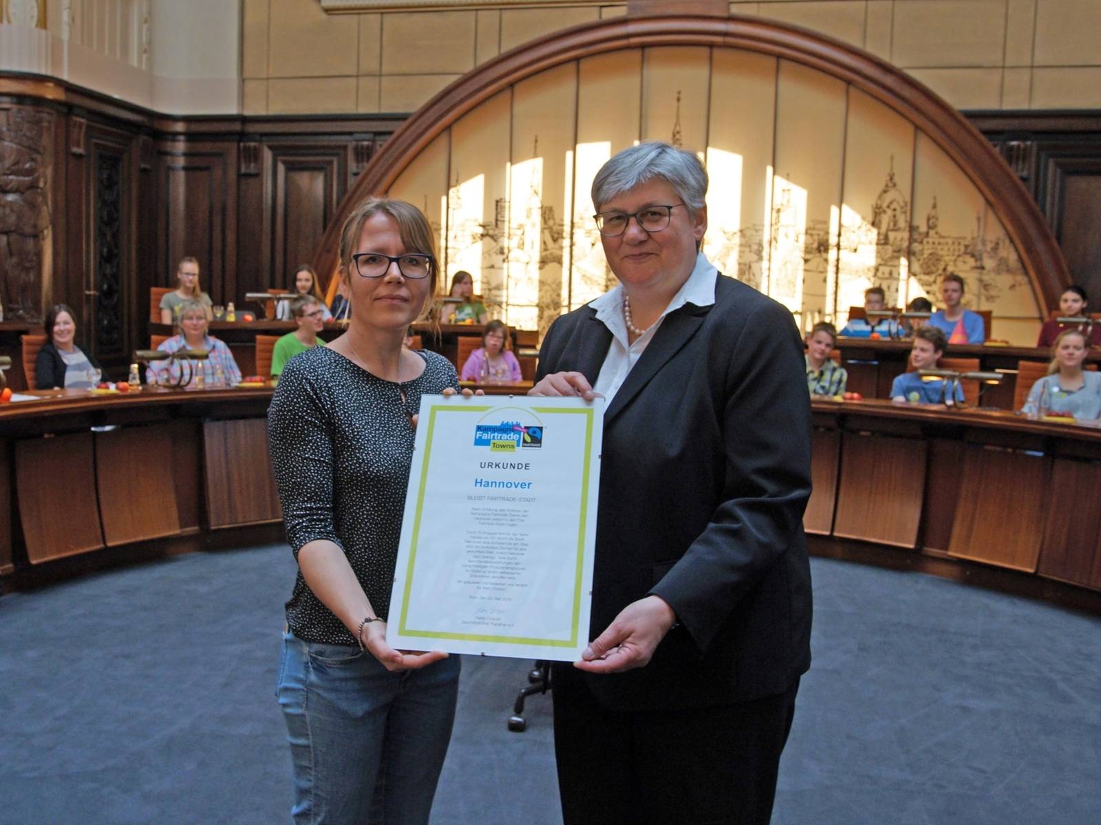 Zwei Frauen mit einer Urkunde. 