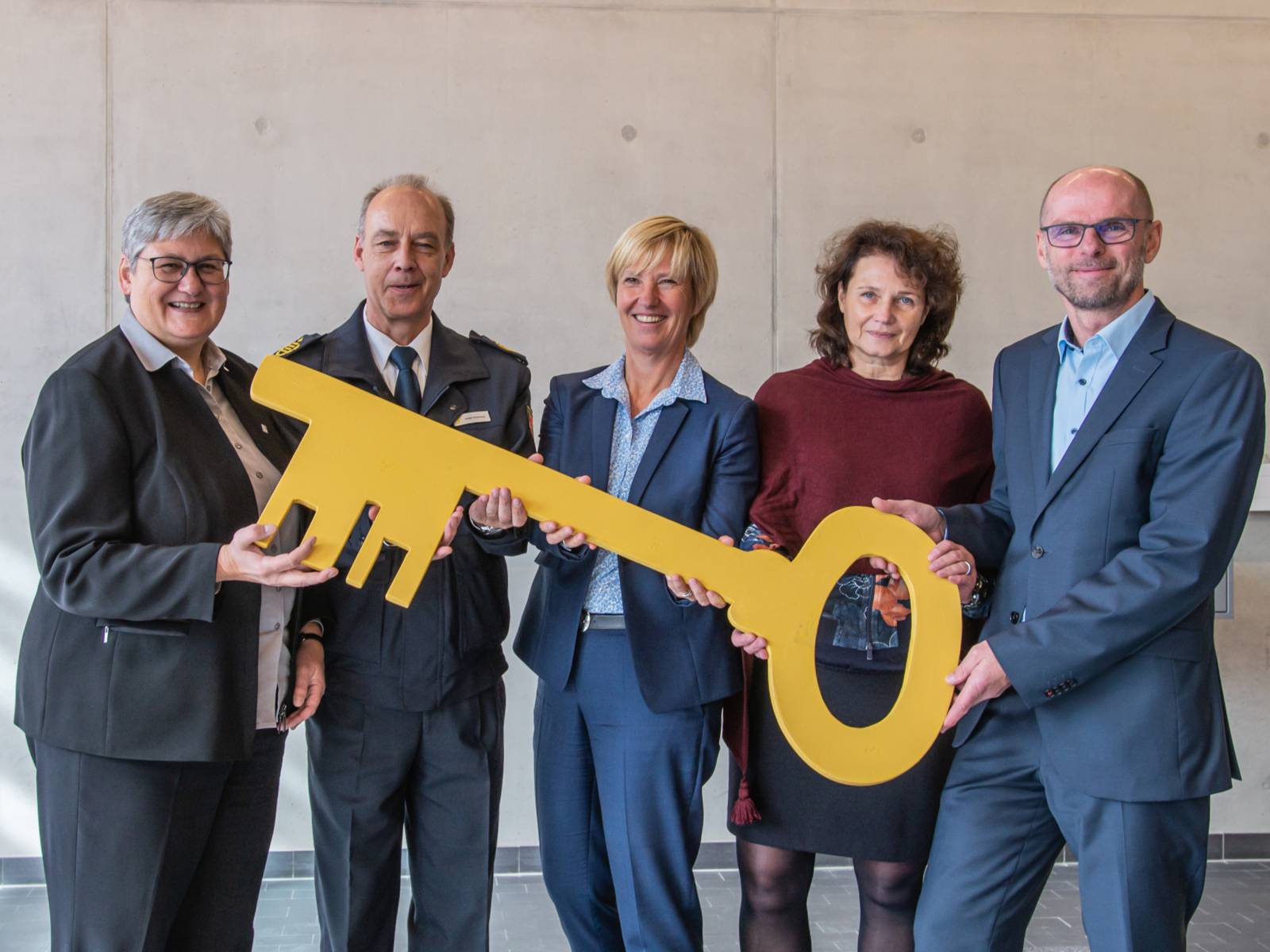 Fünf Personen mit einem großen Schlüssel. 
