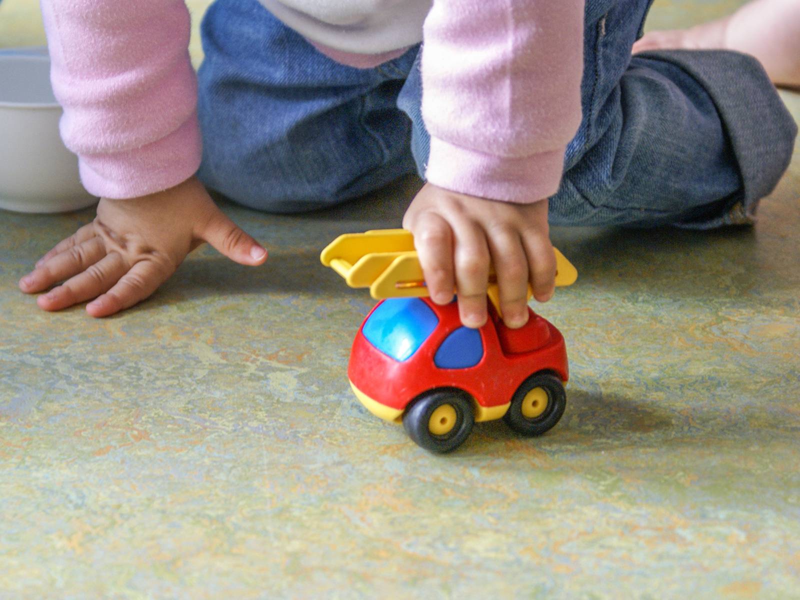 Ein Kind, das mit einem Spielzeugauto spielt