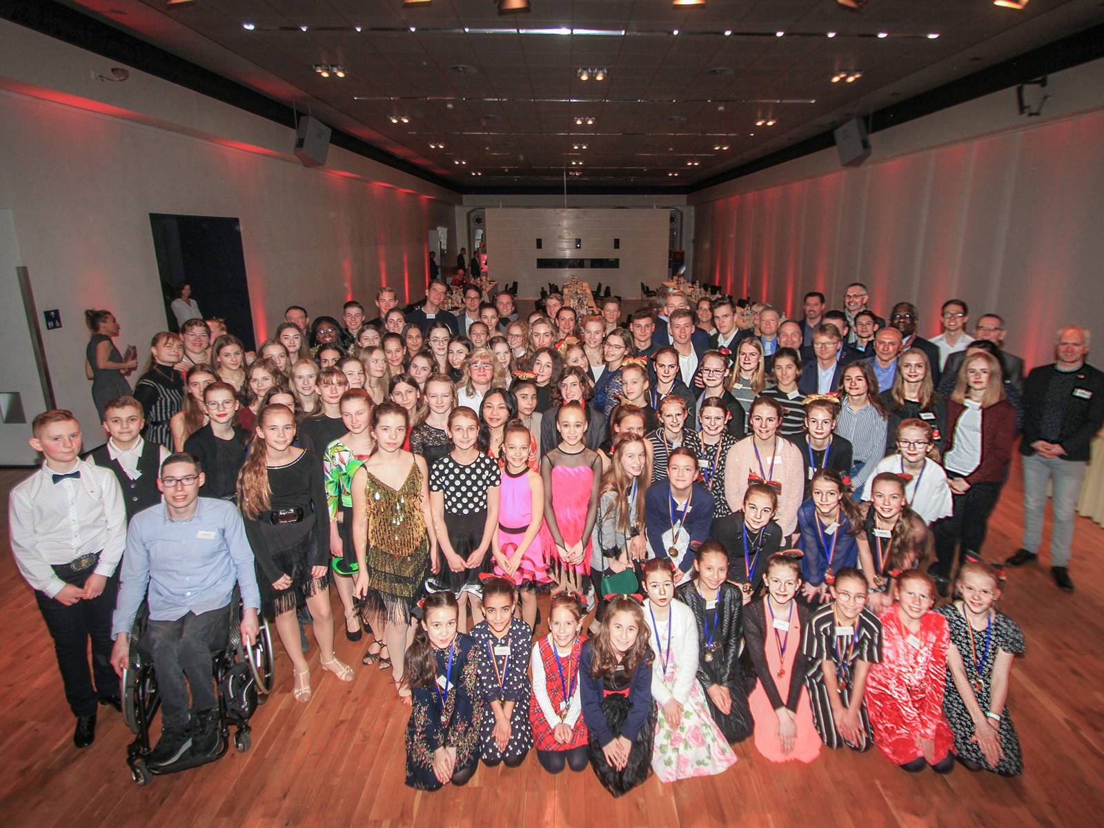 Eine große Gruppe junger Menschen in einem Saal