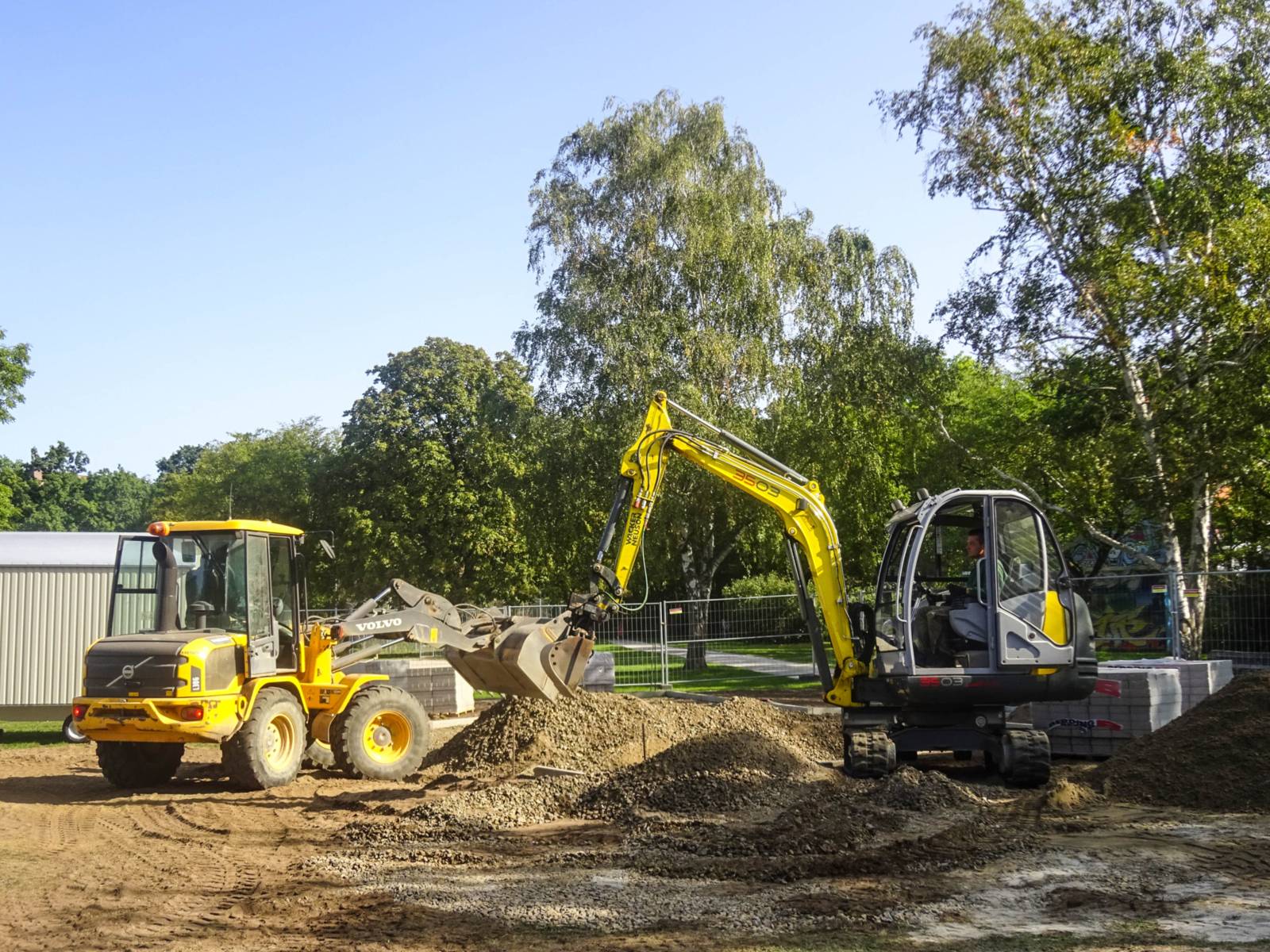 Zwei Bagger auf einer Baustelle. 