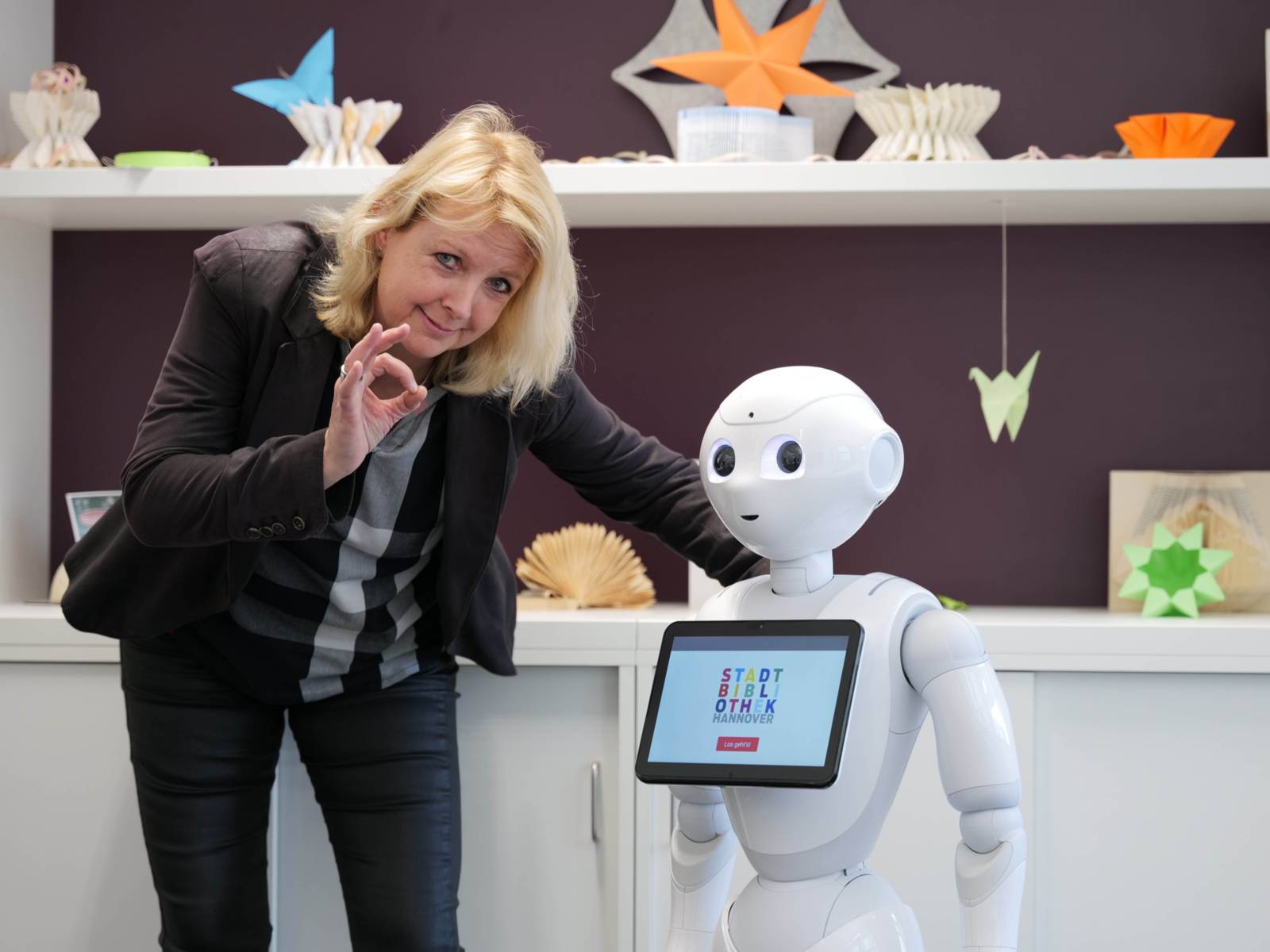 Eine Frau neben einem Roboter. 