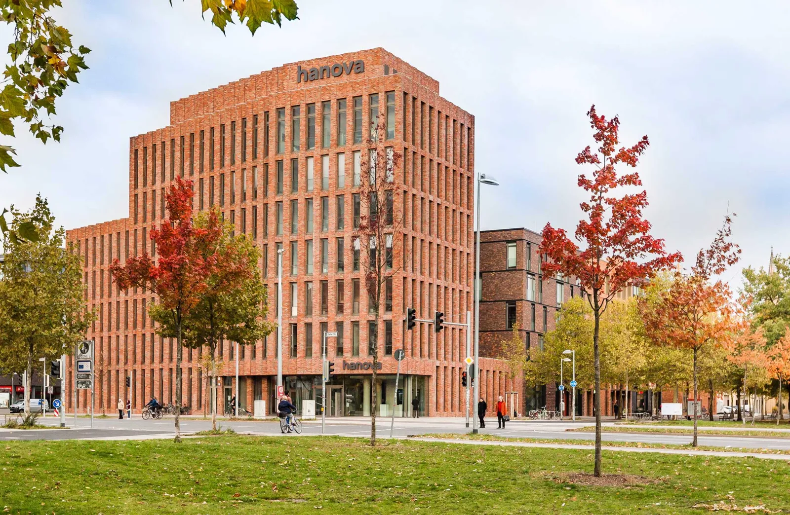 B&uuml;rogeb&auml;ude, davor eine Stra&szlig;e mit einer Ampel und zahlreichen B&auml;umen