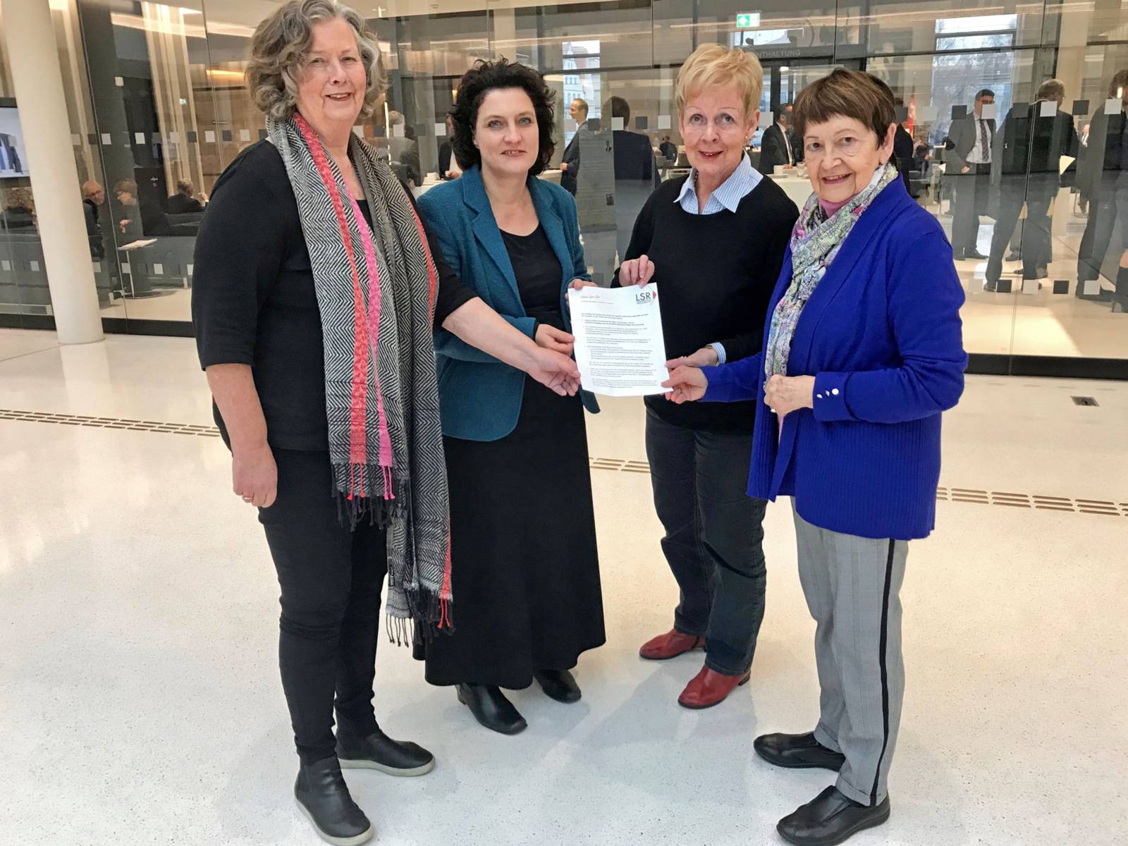 Gruppenaufnahme: Drei Frauen übergeben der Niedersächsischen Ministerin für Soziales, Gesundheit und Gleichstellung, Frau Dr. Carola Reimann, ein Papier.