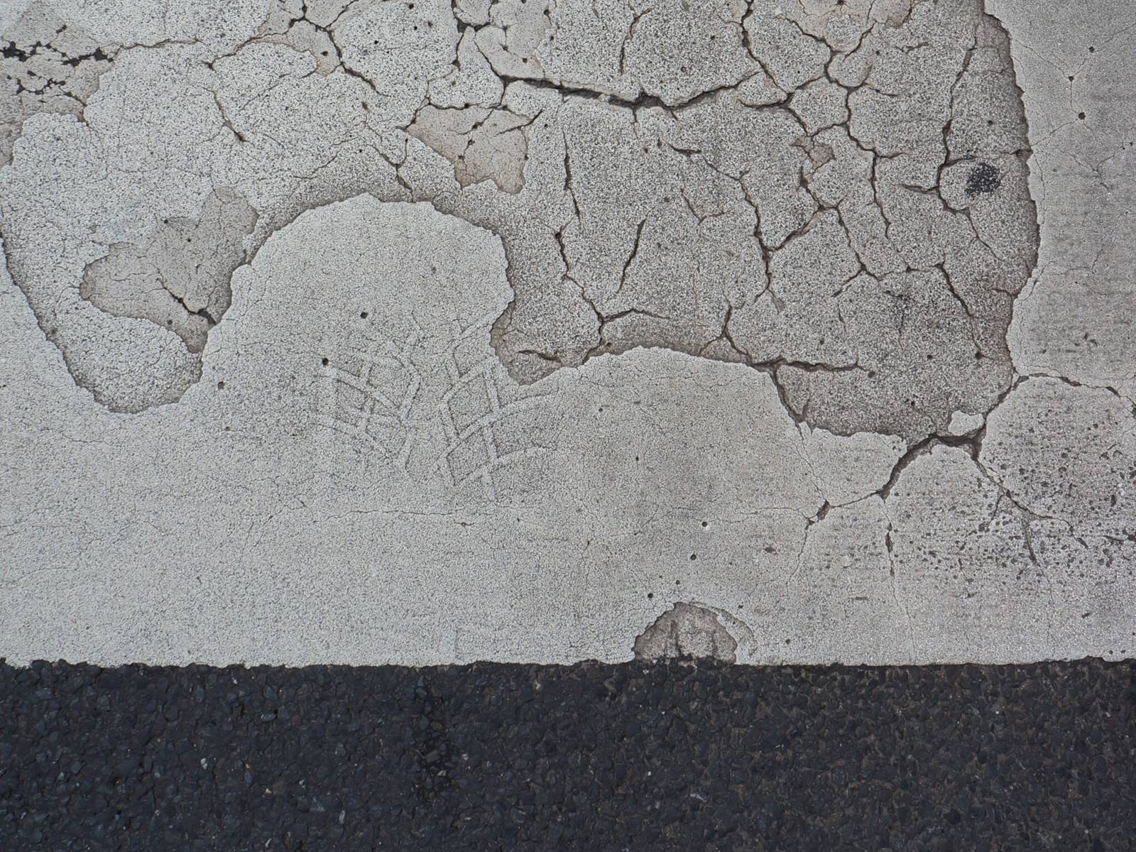 Fußabdruck in einer betonierten Straße