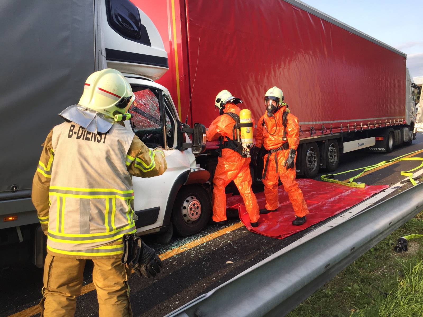 Drei Einsatzkräfte der Feuerwehr Hannover beim Öffnen der Plane des verunfallten LKWs.
