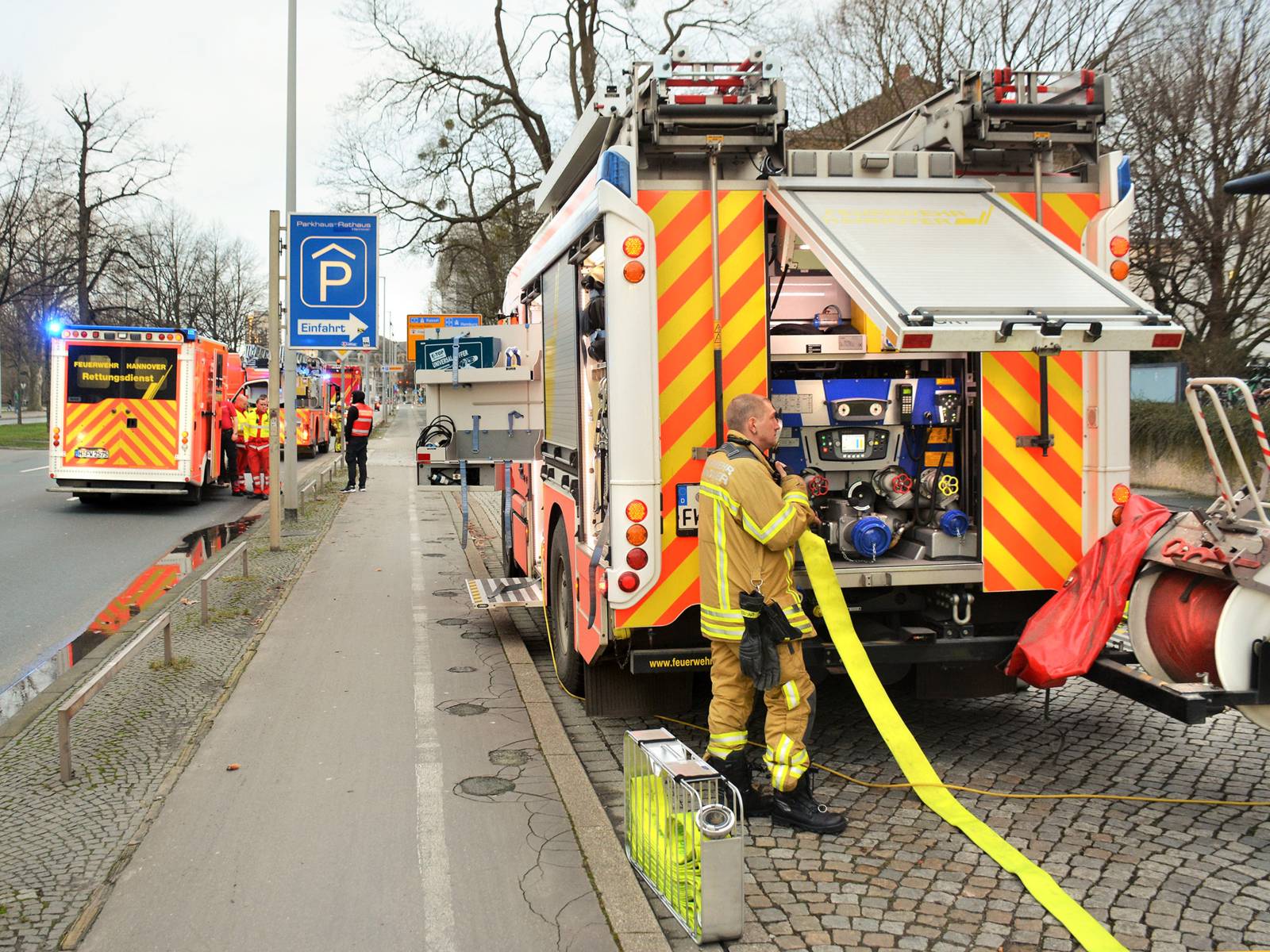 Mehrere Einsatzkräfte und Einsatzfahrzeuge der Feuerwehr Hannover vor der Flüchtlingsunterkunft am Friedrichswall.