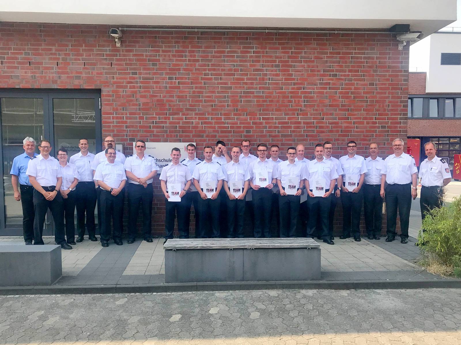 Die Leitung der Feuerwehr, Vertreter des Örtlichen Personalrates sowie das Ausbilderte-am gratulieren den 13 jungen Kollegen nach bestandener Prüfung zum Notfallsanitäter.