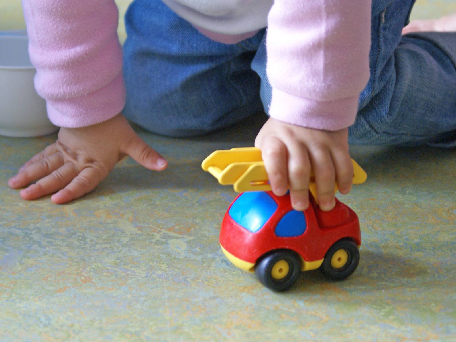 Ein Kleinkind spielt mit einem Spielzeugauto.