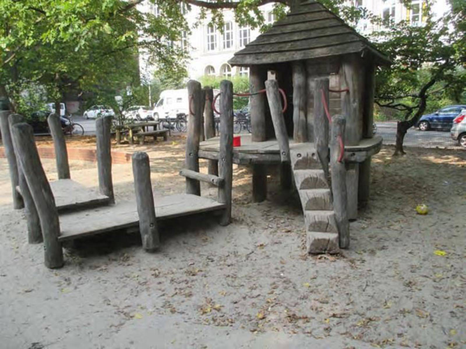 Holzspielgeräte auf sandigem Untergrund auf einem Spielplatz