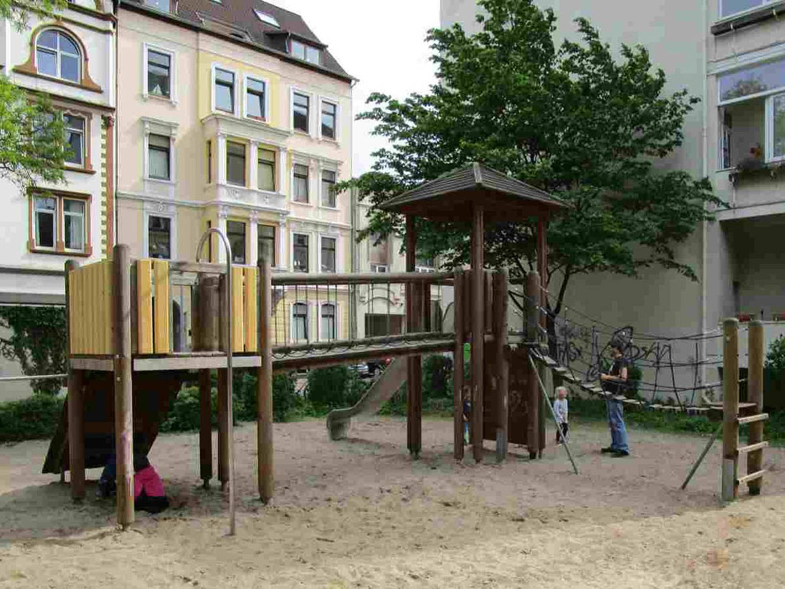 Ein Holzspielgerät mit Rutsche und Klettermöglichkeiten auf dem Spielpatz Gerberstraße