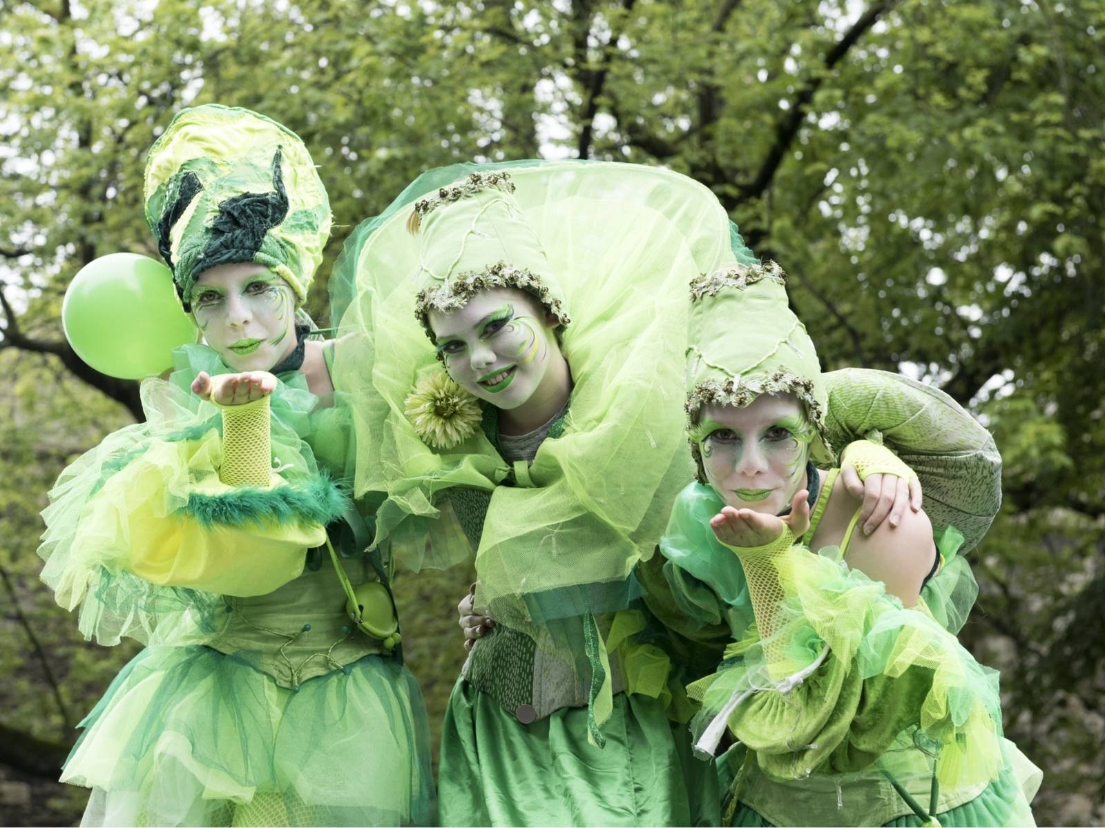Drei grün gekleidete Fantasiefiguren (Walk-Acts) beim Autofreien Sonntag