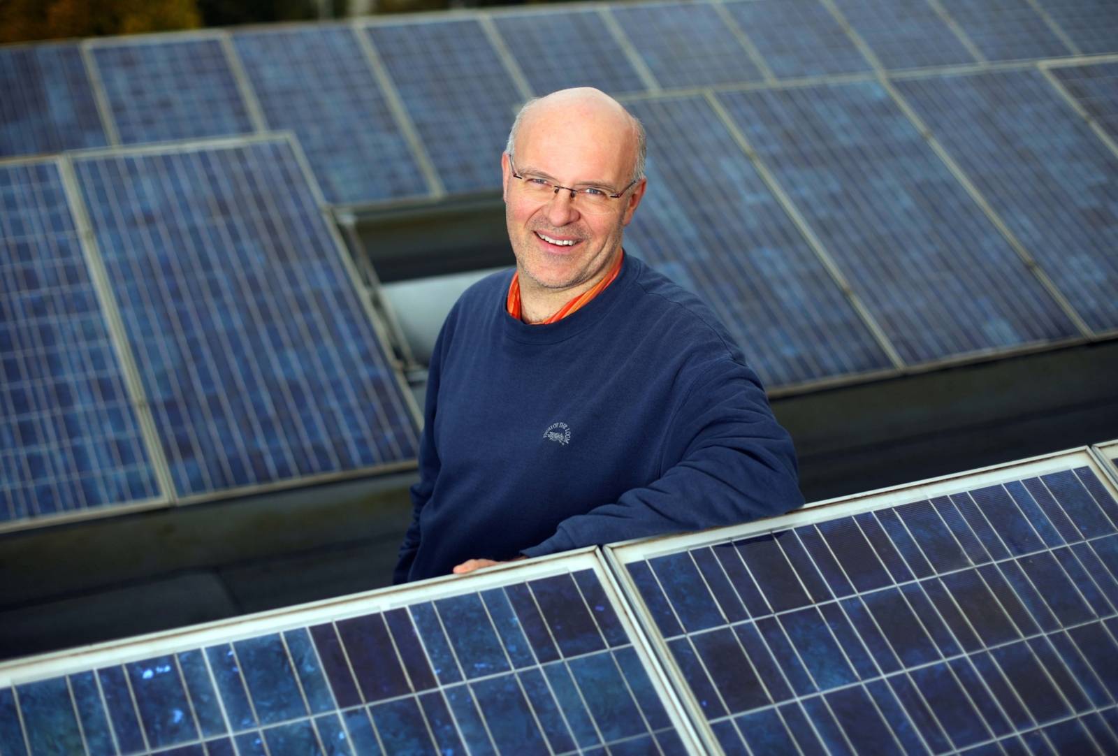 Energieberater Dirk Hufnagel zwischen einer Photovoltaikanlage