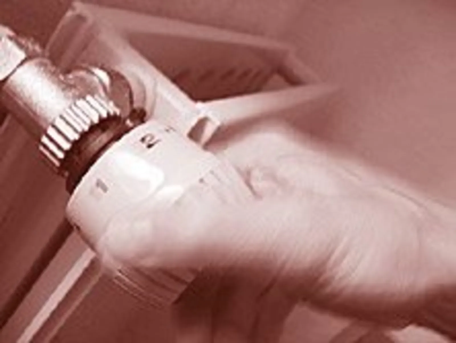Eine Hand dreht am Heizungsregler