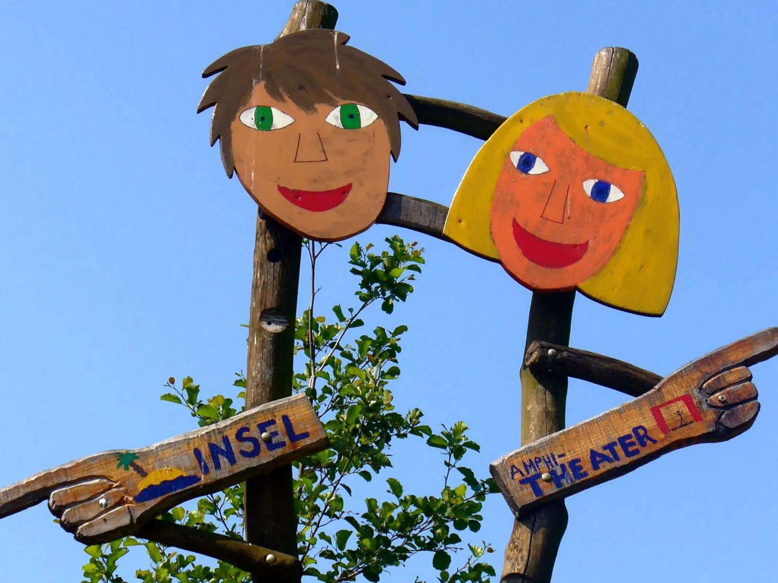 Zwei Kinderköpfe aus Holz.