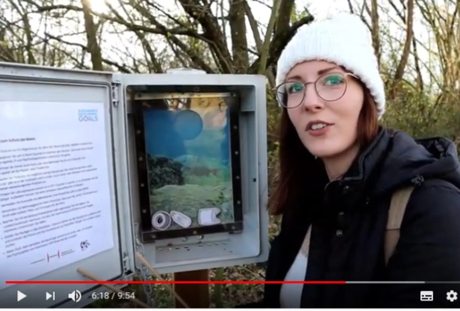 Eine junge Frau steht vor einem geöffneten Cache zum Thema "Leben im Wasser"