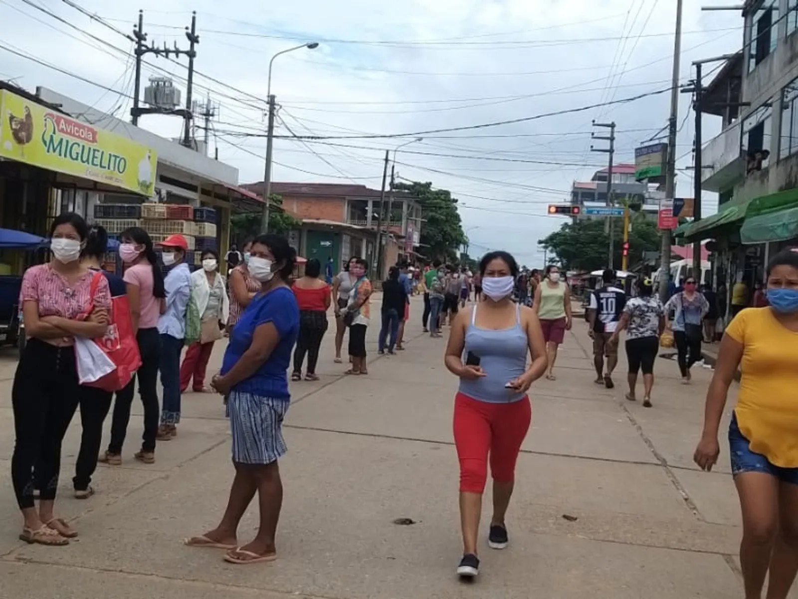 Menschen mit Mundschutz in den Straßen von Yarinacocha in Peru.