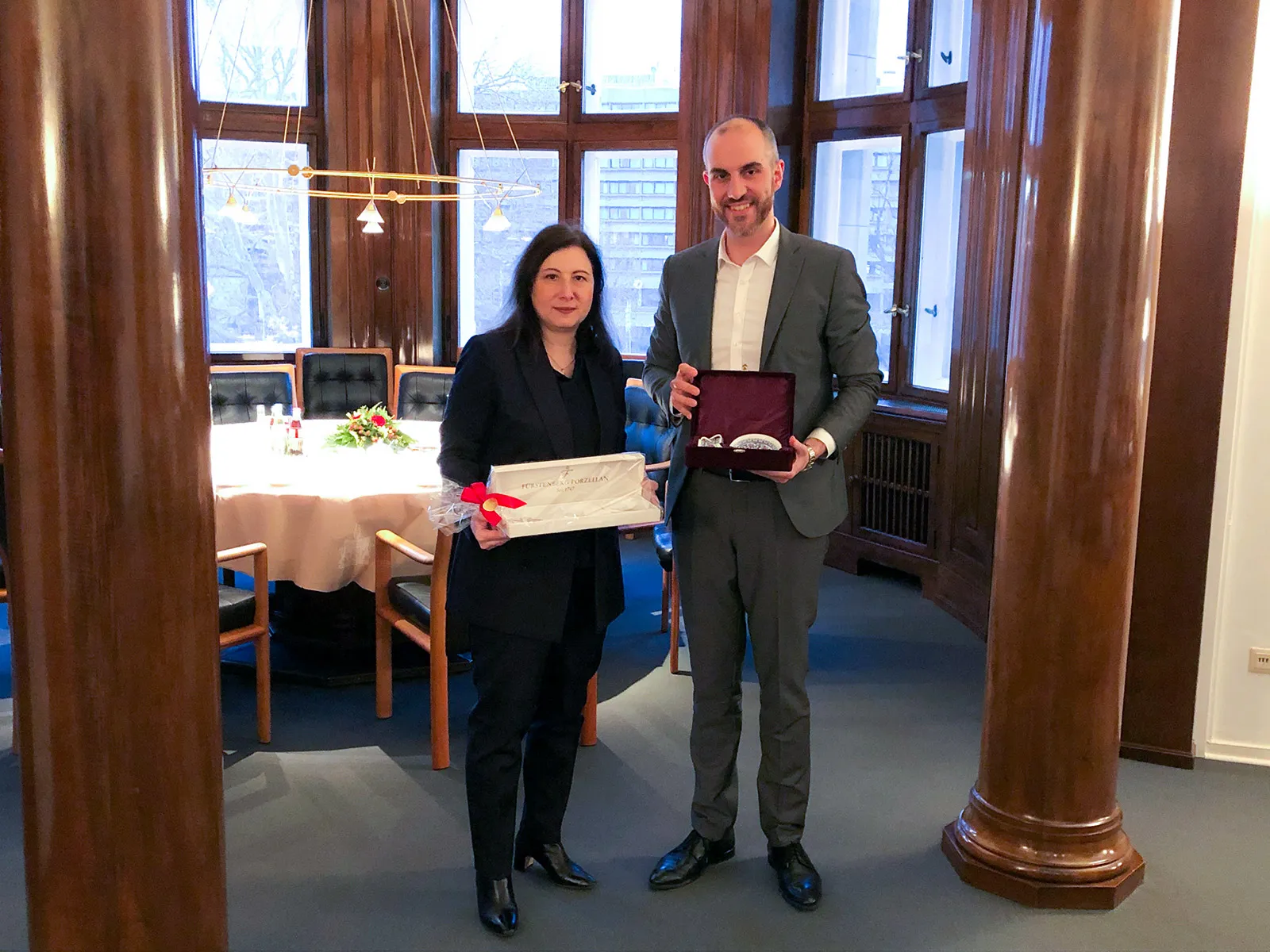 Die türkische Generalkonsulin Banu Malaman und Hannovers Oberbürgermeister Belit Onay posieren vor einem gedeckten Tisch mit Presenten in den Händen.
