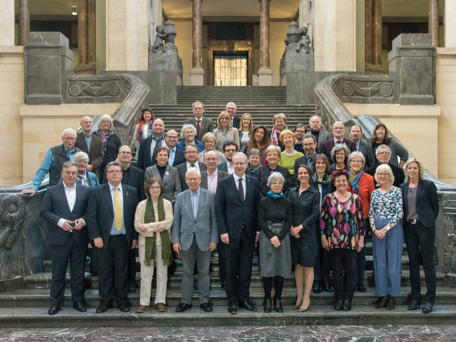 Gruppenaufnahme von ca. 45 Personen auf der Treppe im Eingangsbereich des Neuen Rathauses in Hannover