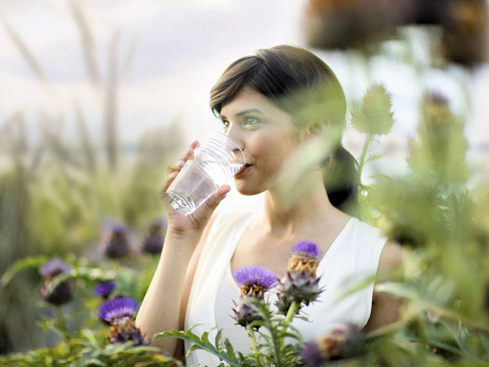Frau trinkt aus Wasserglas
