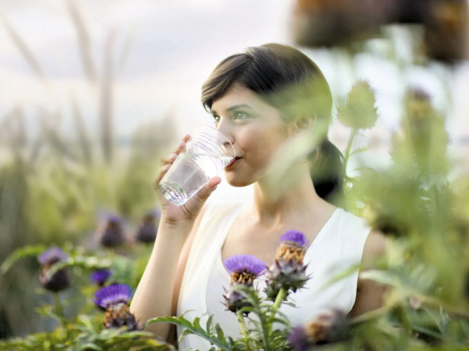 Frau trinkt aus Wasserglas