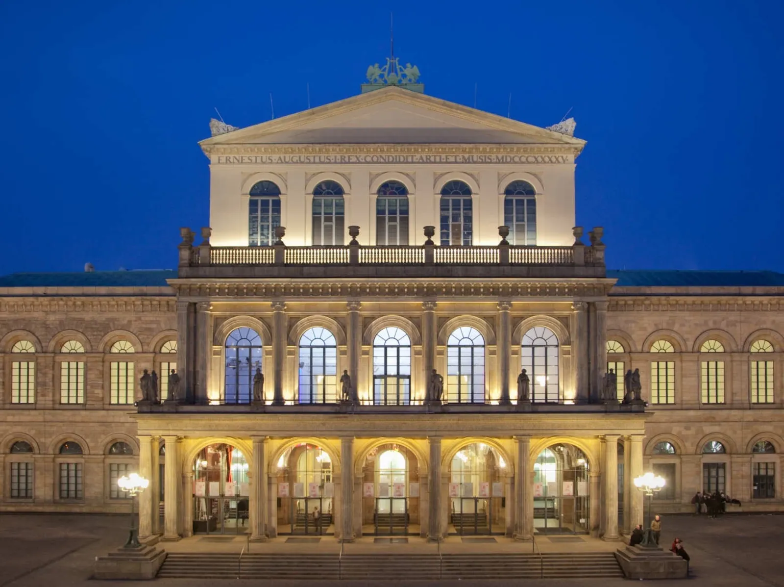 Das erleuchtete Opernhaus in der Frontansicht bei Nacht.