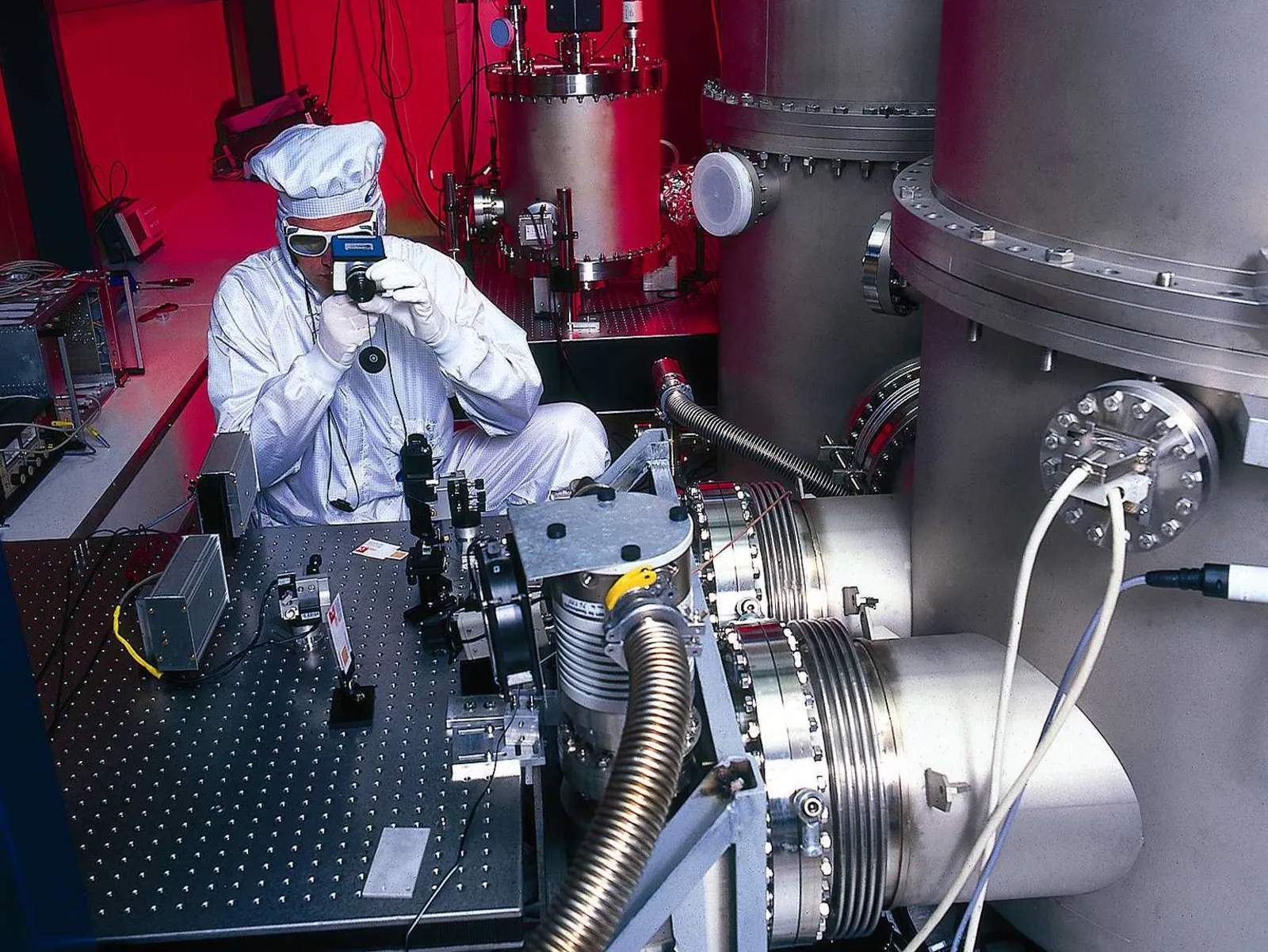 Eine Person in einem Schutzanzug filmt eine große Maschine.