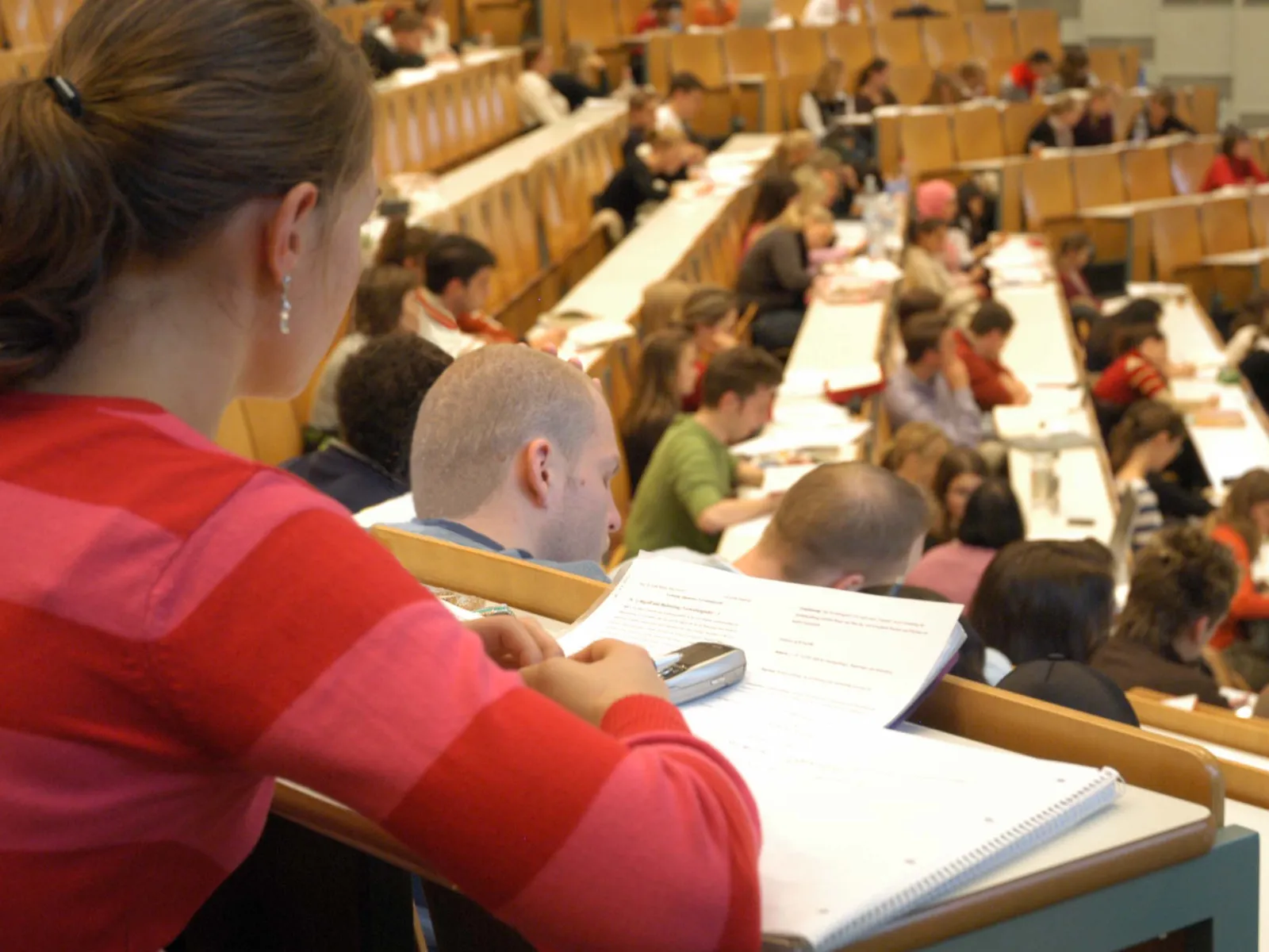 Viele Junge Menschen sitzen in einem großen Raum.