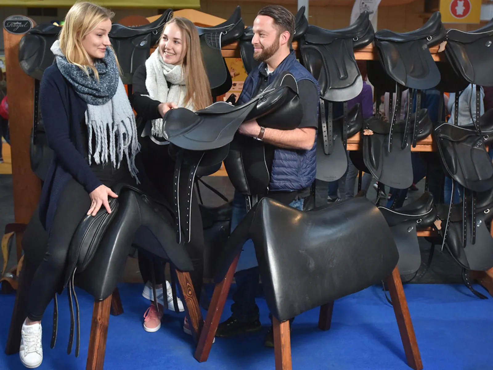 Zwei Frauen und ein Mann mit Sätteln