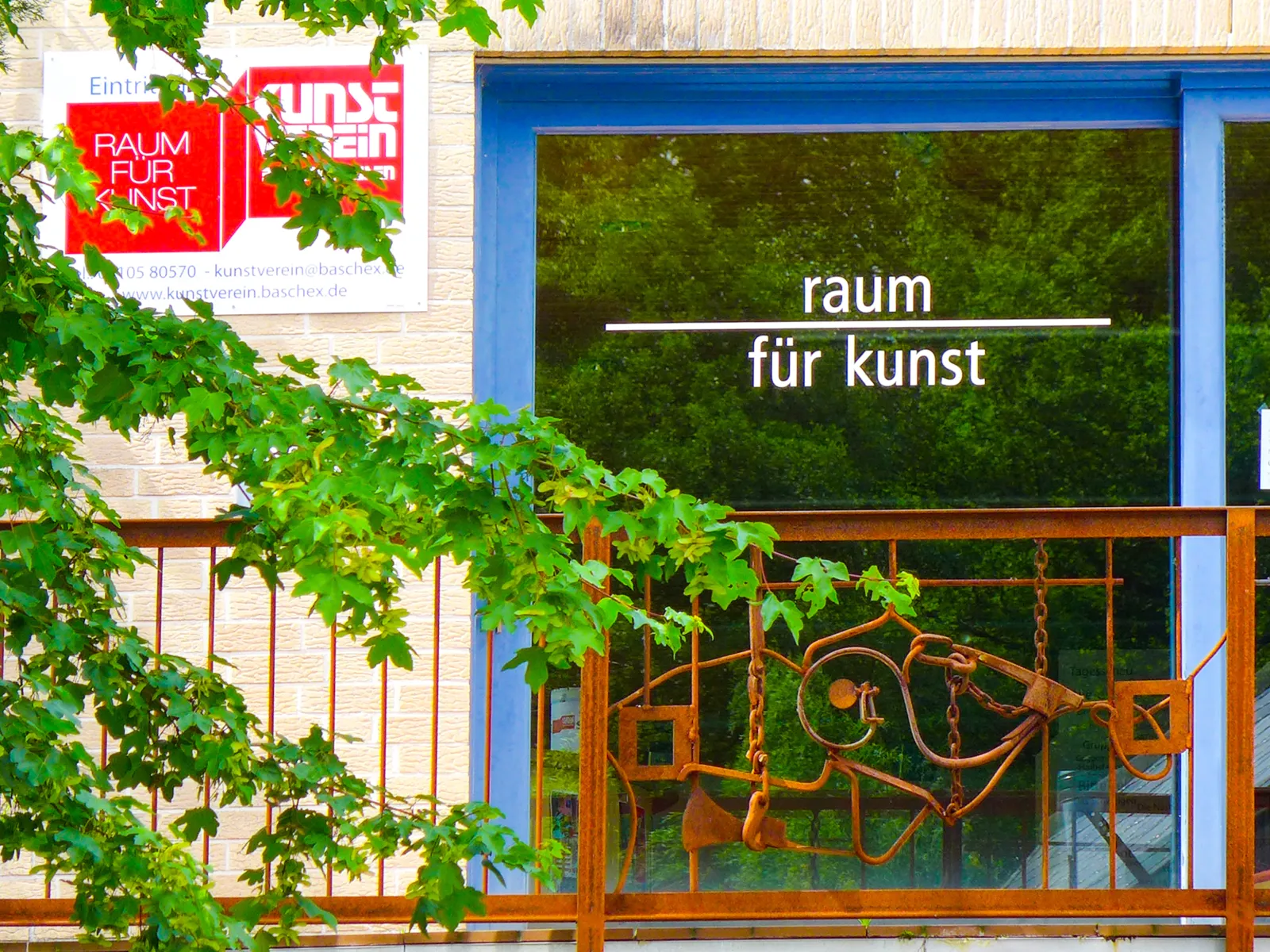 Gläserne Eingangstür mit dem Schriftzug Raum für Kunst.