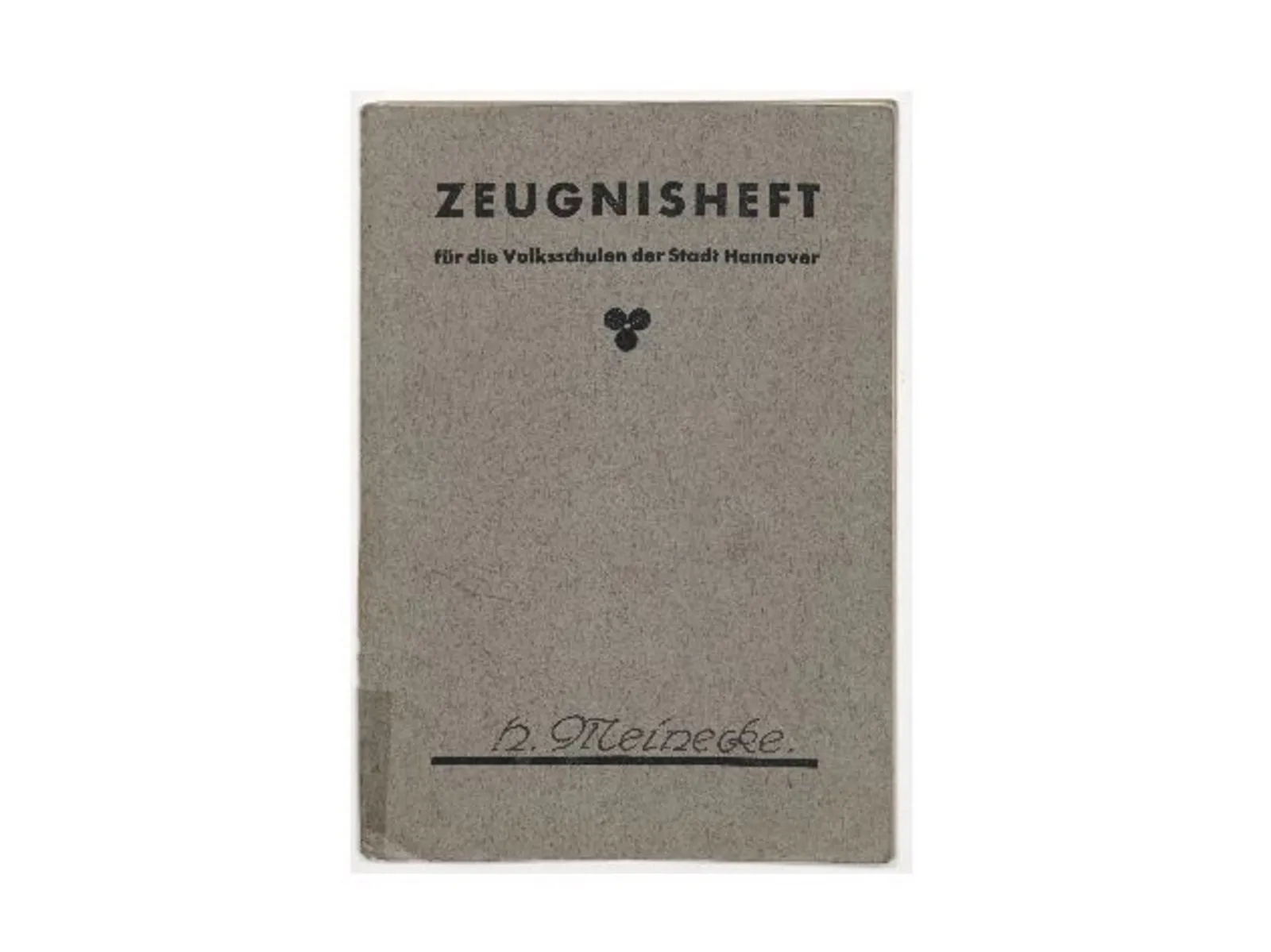 Graues Heft im Hochformat, das oben den Aufdruck Zeugnisheft für die Volksschulen der Stadt Hannover trägt. Unten ist handschriftlich H. Meinecke eingetragen.

