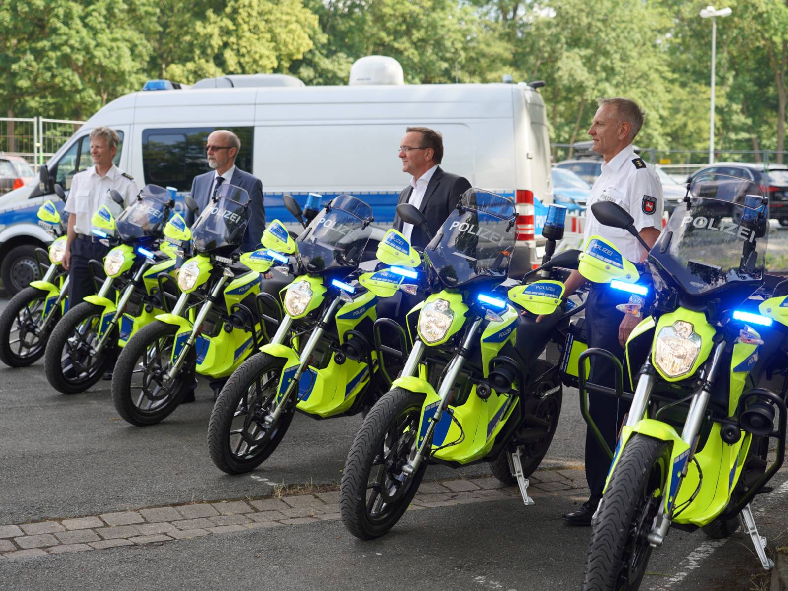 Polizisten stehen neben Motorrädern