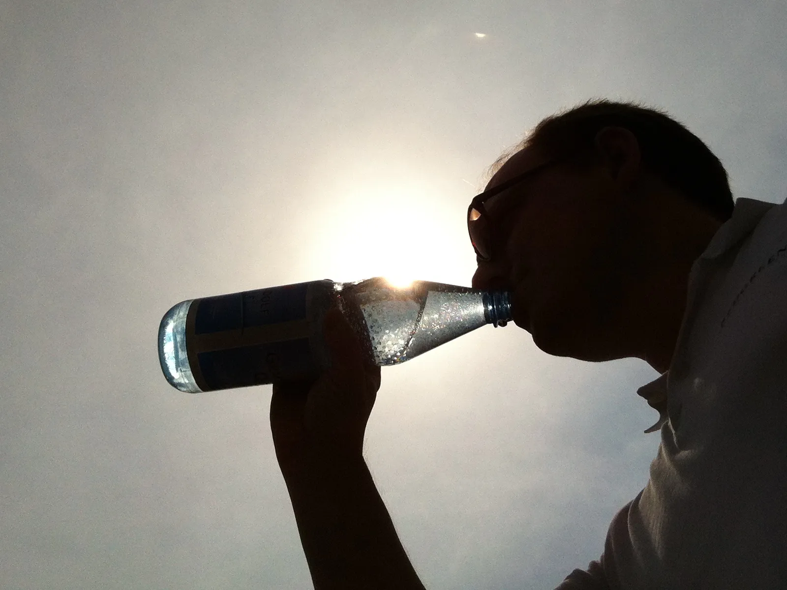 Ein Mann trinkt aus einer Flasche 