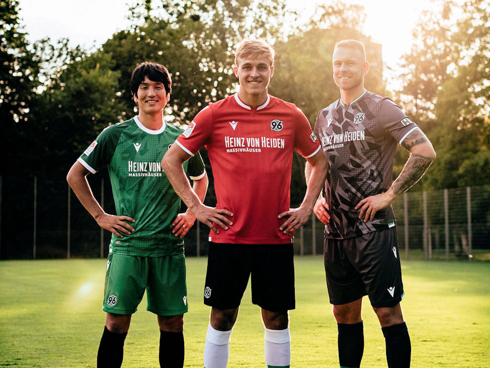 Drei Fußballspieler in Trikots von Hannover 96