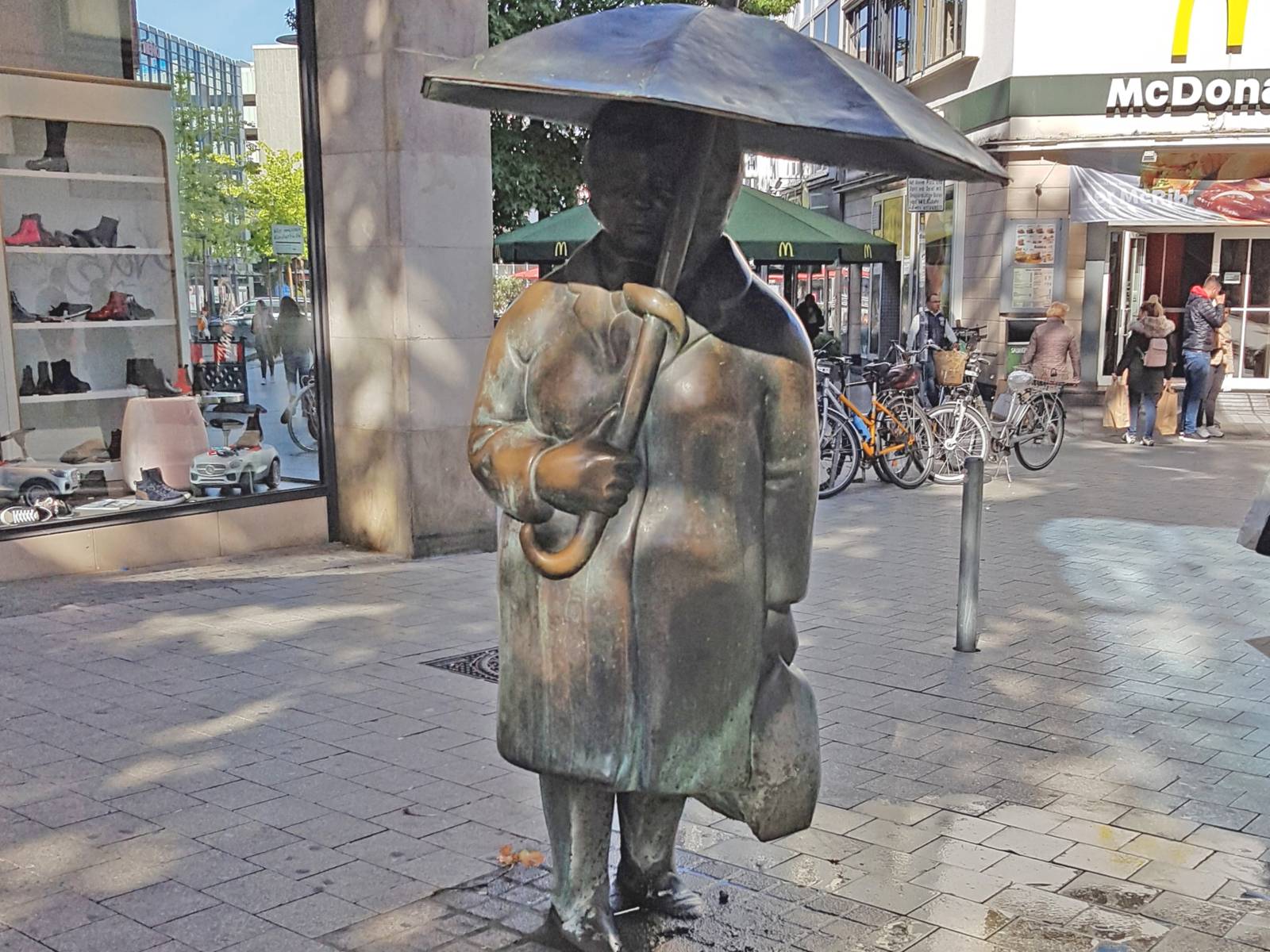 Skupltur einer Frau mit Regenschirm