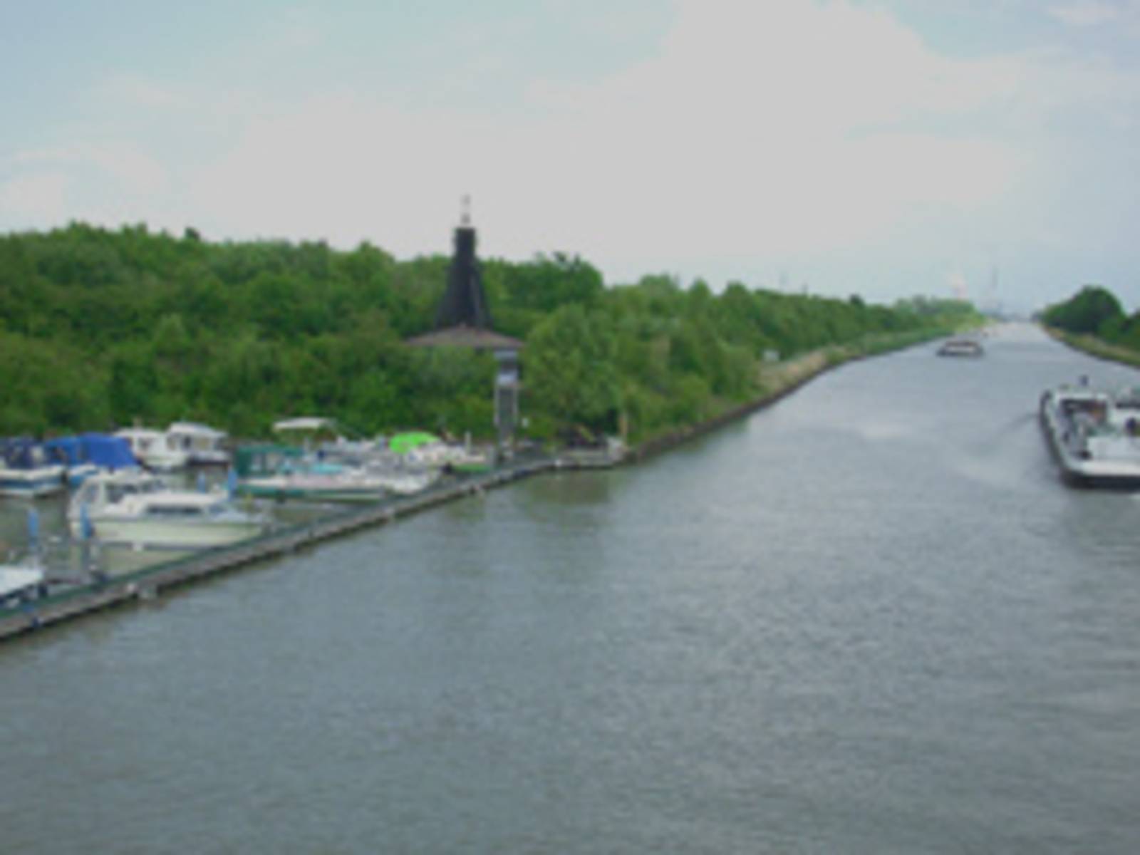 Der Mittellandkanal, rechts ein Yachthafen, links eine Binnenschiff
