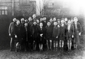 Pupils with a teacher in front of the northern side of the school building in 1940