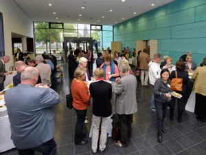 Menschen im Foyer der Hildesheimer Stra&szlig;e 18 bei einem kleinen Imbiss