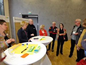 Gruppe von Personen um zwei Stehtische stehend