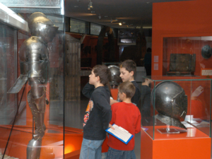 Besucher in der Dauerausstellung Abteilung „Ritter-Bürger-Fürstenmacht“. Kinder an der Ritterrüstung. 