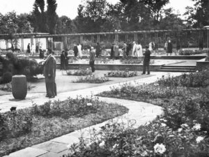 Historische Aufnahme des Stadtparks aus 1951: Flanierende Besucher zwischen terrassenförmig angelegten Blumenbeeten.